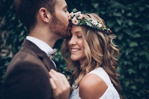 Bride with wavy hair and a flower crown celebrating with her husband